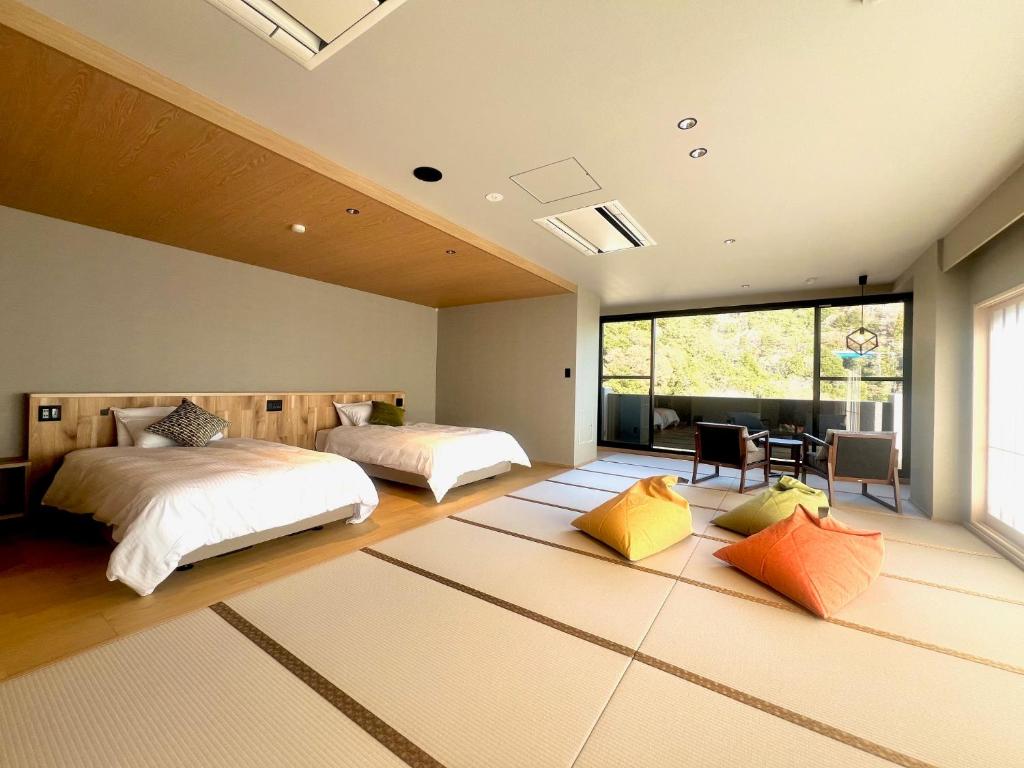 une chambre avec deux lits et une grande fenêtre dans l'établissement Hotel Yunomoto, à Komono