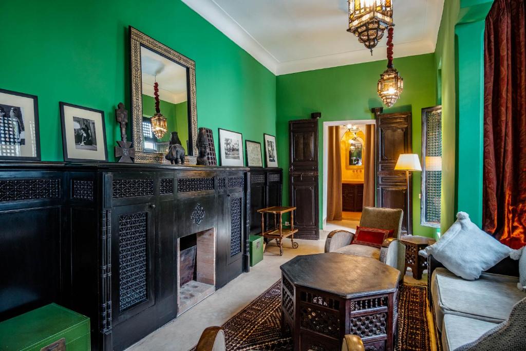d'un salon avec une cheminée et des murs verts. dans l'établissement Riad El Ayadi, Moorish villa, à Marrakech