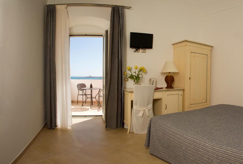 une chambre avec un lit et une vue sur l'océan dans l'établissement Hotel Boutique Il Castellino Relais, à Vieste