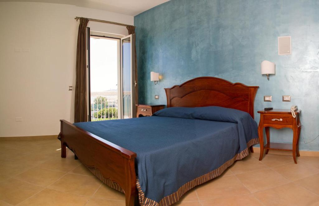 une chambre avec un lit et un mur bleu dans l'établissement Hotel Boutique Il Castellino Relais, à Vieste 74 autres photos