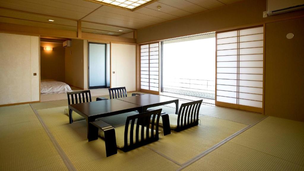une salle à manger avec une table et des chaises et une chambre dans l'établissement Fugaku Hanabusa, à Izunokuni