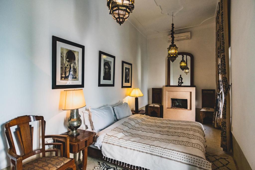 - une chambre avec un lit, deux chaises et un miroir dans l'établissement Riad El Ayadi, Moorish villa, à Marrakech
