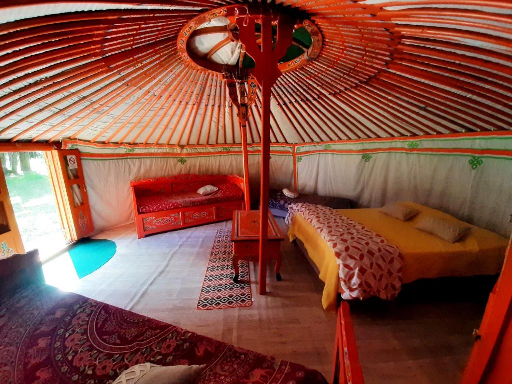 Cette chambre comprend une tente avec un lit et un canapé. dans l'établissement Yourtes Corse Le pré aux biches, à Zonza