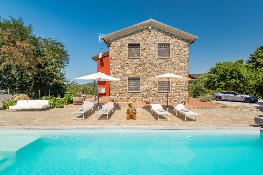 une maison avec piscine devant un immeuble dans l'établissement Villa Emozione, à Sarzana