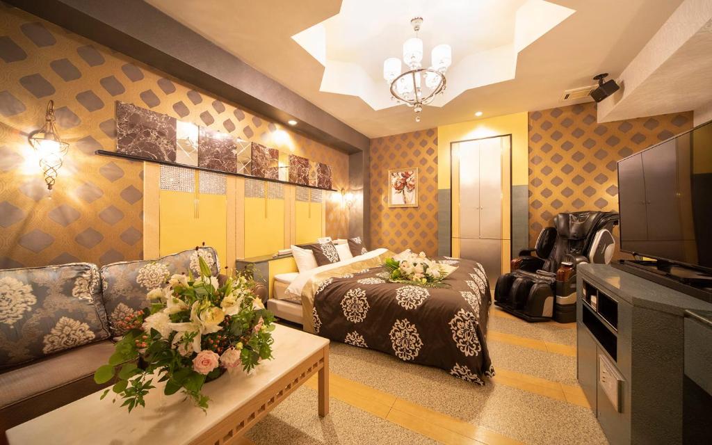 un salon avec un canapé et une télévision dans l'établissement イスパニア花園, à Fukaya