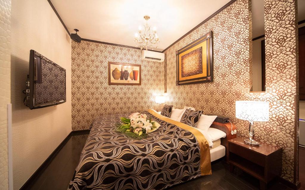 une chambre d'hôtel avec un lit avec des fleurs dessus dans l'établissement イスパニア花園, à Fukaya