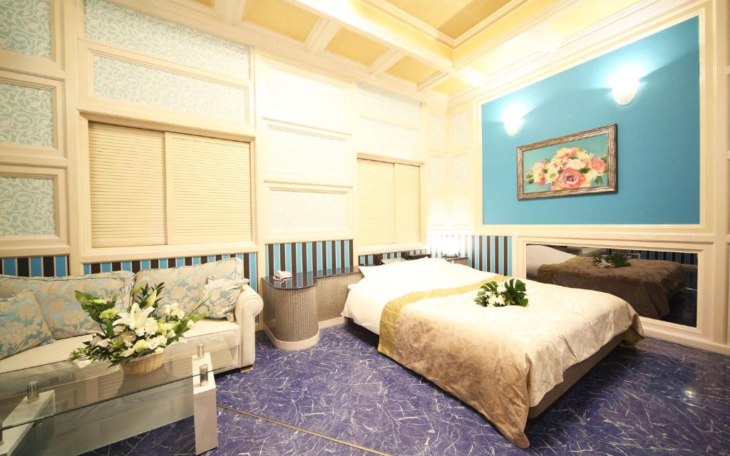 une chambre avec deux lits et un canapé dans l'établissement ハーフムーン富士宮 Adult only, à Fujinomiya