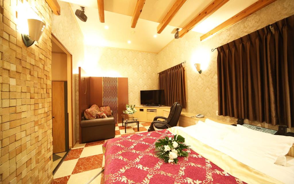 une chambre avec un lit et une chaise dans une pièce dans l'établissement ハーフムーン富士宮 Adult only, à Fujinomiya