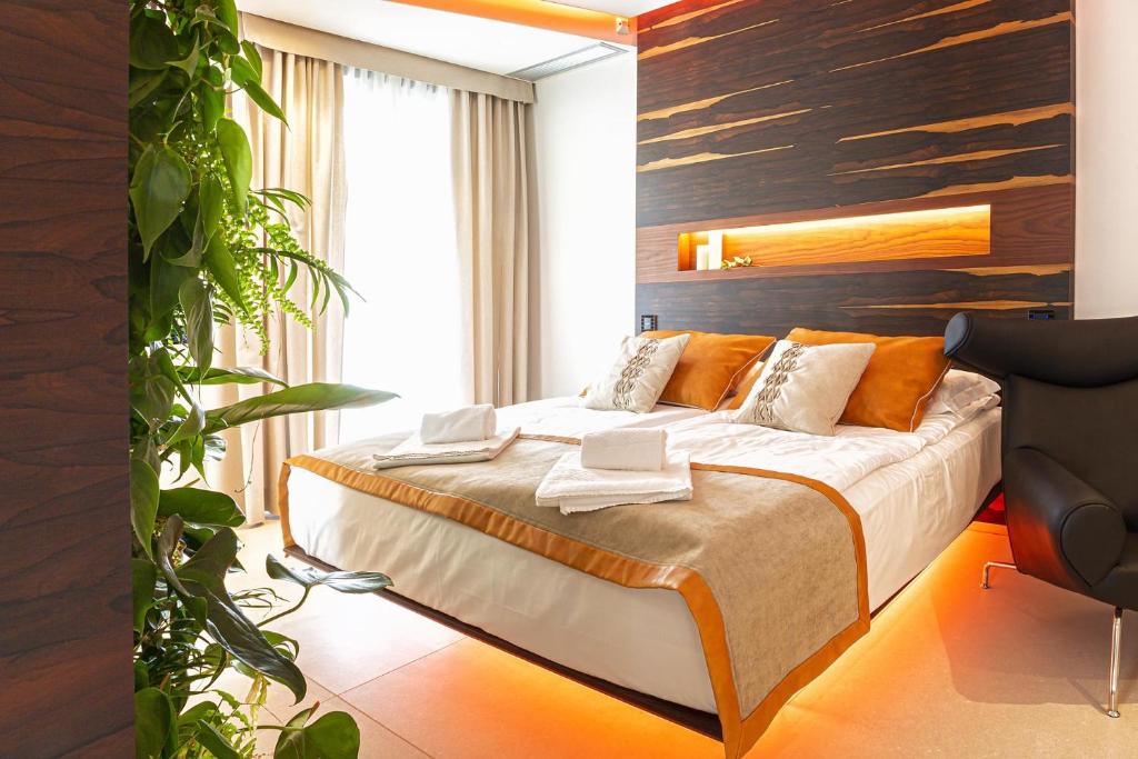 une chambre avec un lit et une plante dans l'établissement Costa Rica Bibione SPA, à Bibione