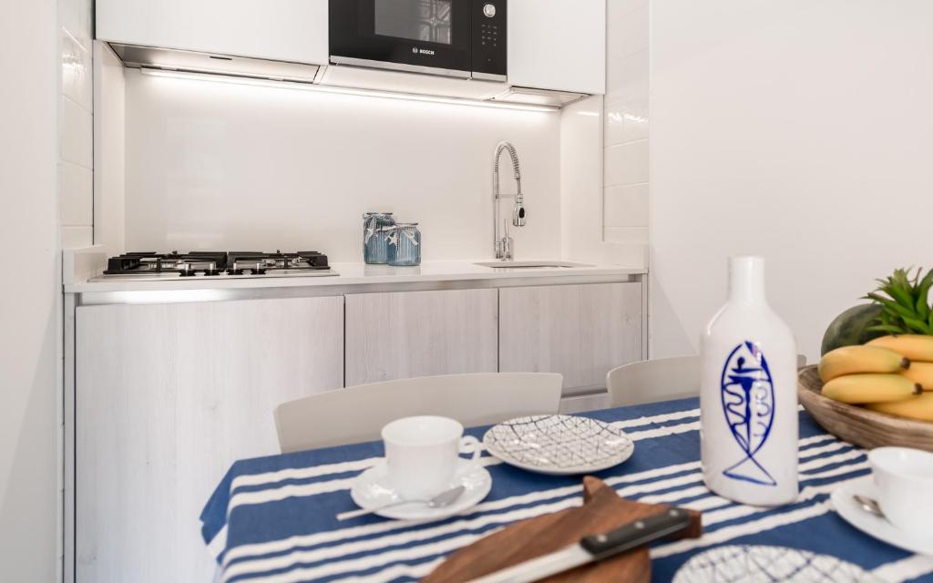 une cuisine avec une table avec un chiffon bleu et blanc dans l'établissement Costa Rica Bibione Eco Resort, à Bibione 87 autres photos
