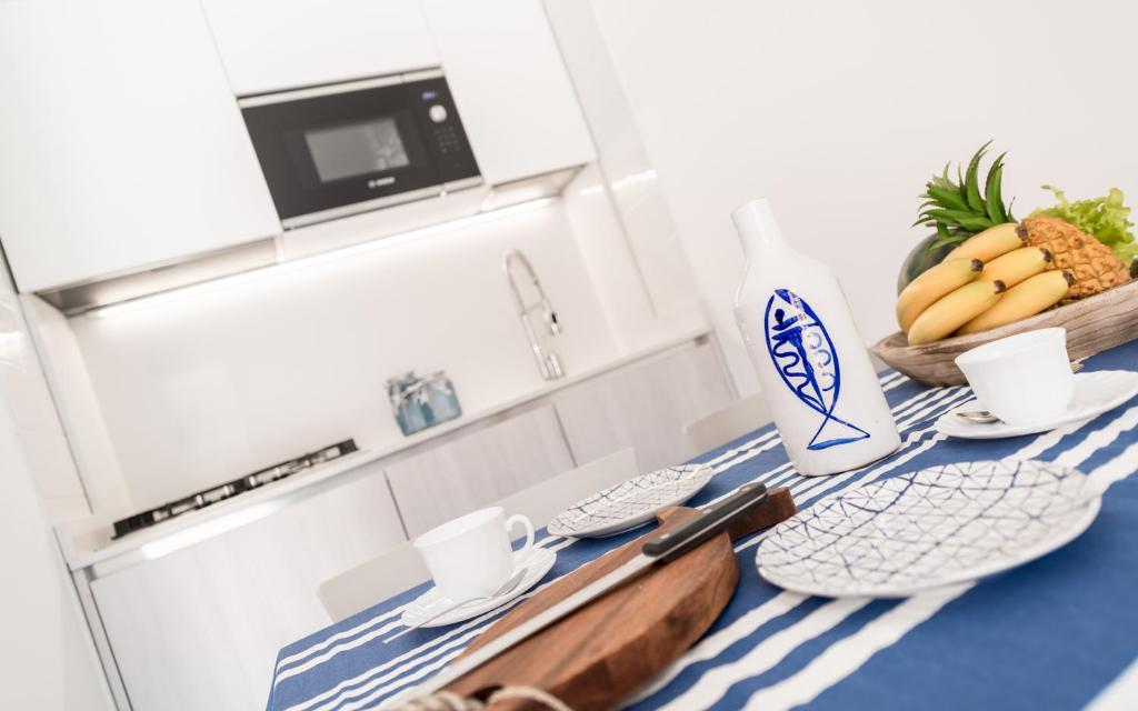 - une cuisine avec une table, un bol de bananes et une bouteille de lait dans l'établissement Costa Rica Bibione Eco Resort, à Bibione