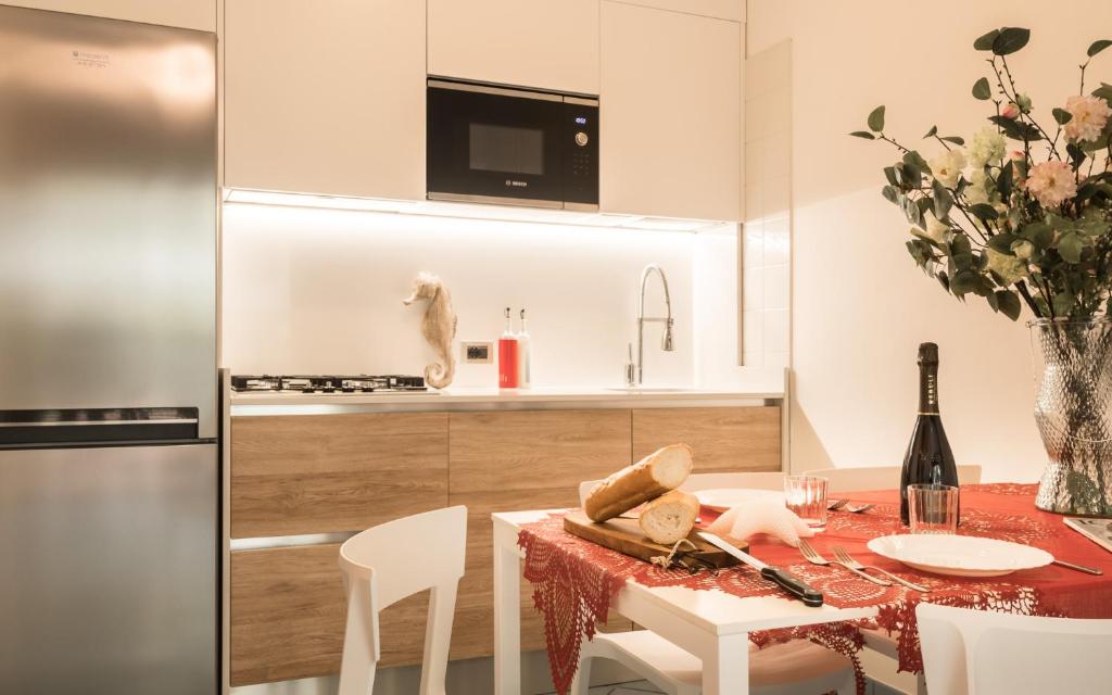 une cuisine et une salle à manger avec une table et un réfrigérateur dans l'établissement Costa Rica Bibione Eco Resort, à Bibione