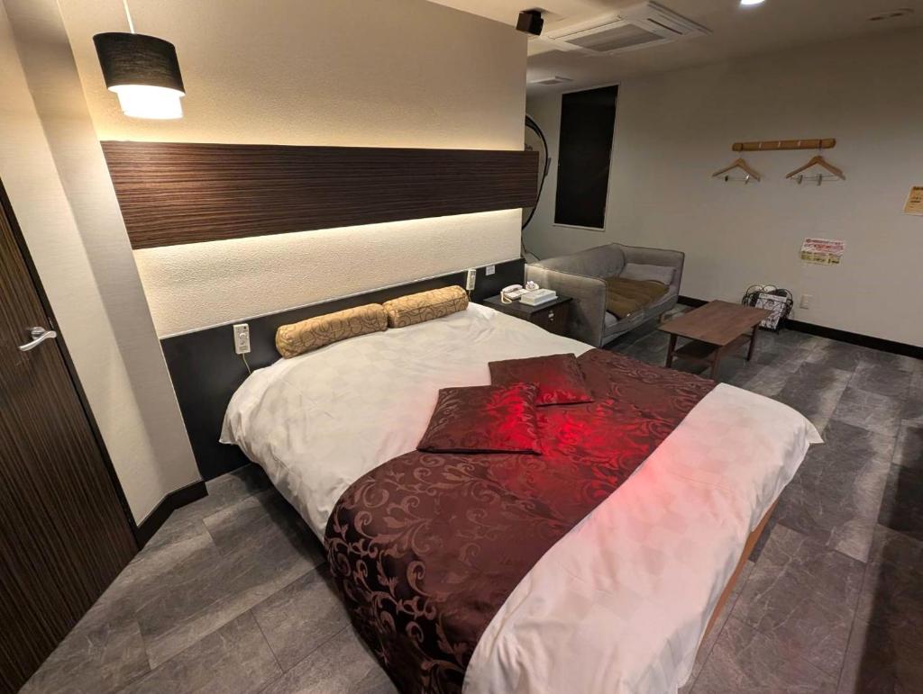 une chambre avec un grand lit dans une pièce dans l'établissement HOTEL Pierrot 泉大津, à Izumiotsu