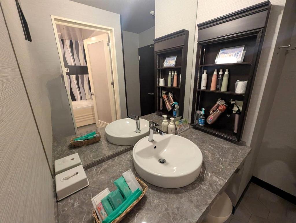 une salle de bain avec deux lavabos et un miroir dans l'établissement HOTEL Pierrot 泉大津, à Izumiotsu