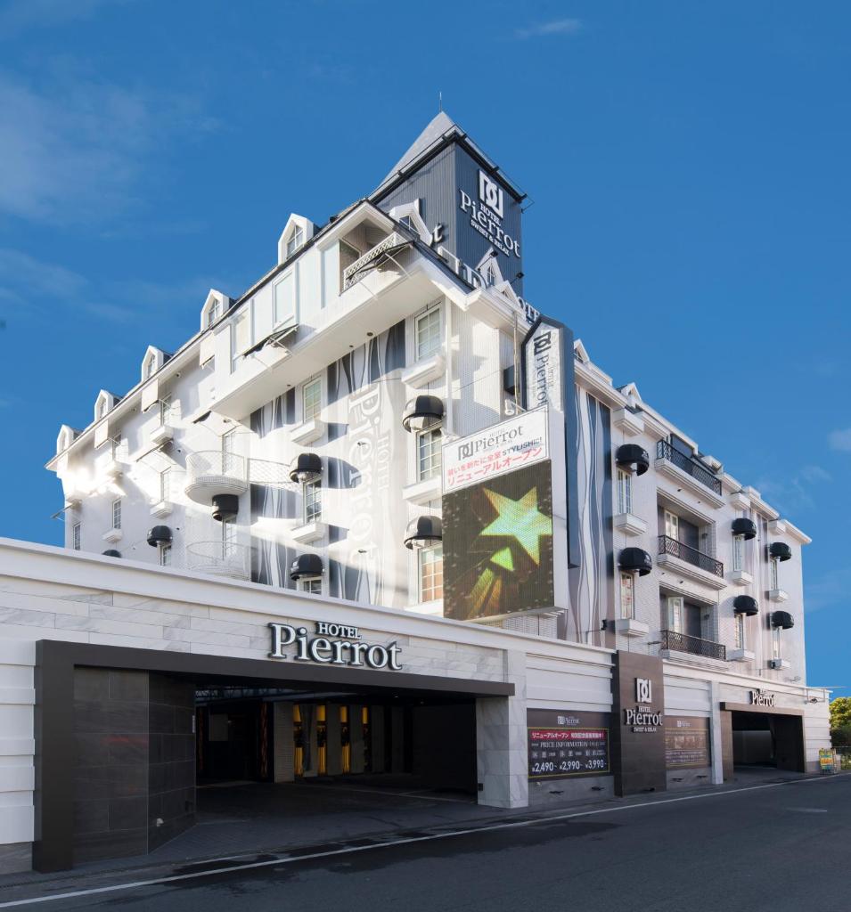un grand bâtiment blanc avec une enseigne dessus dans l'établissement HOTEL Pierrot 泉大津, à Izumiotsu