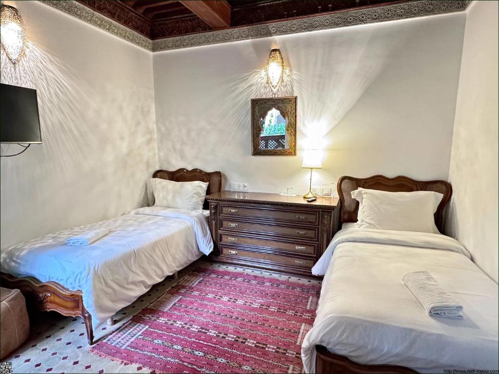 - une chambre avec 2 lits et une commode dans l'établissement Riad Toyour- Riad of birds, à Fès