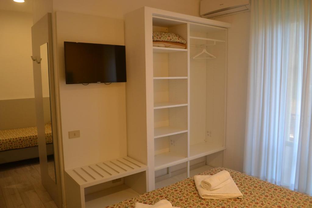 Cette chambre dispose d'un placard, d'une télévision et d'un lit. dans l'établissement Hotel Mirage, à Lido di Jesolo