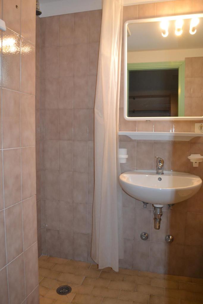 une salle de bain avec un lavabo et un miroir dans l'établissement Hotel Mirage, à Lido di Jesolo