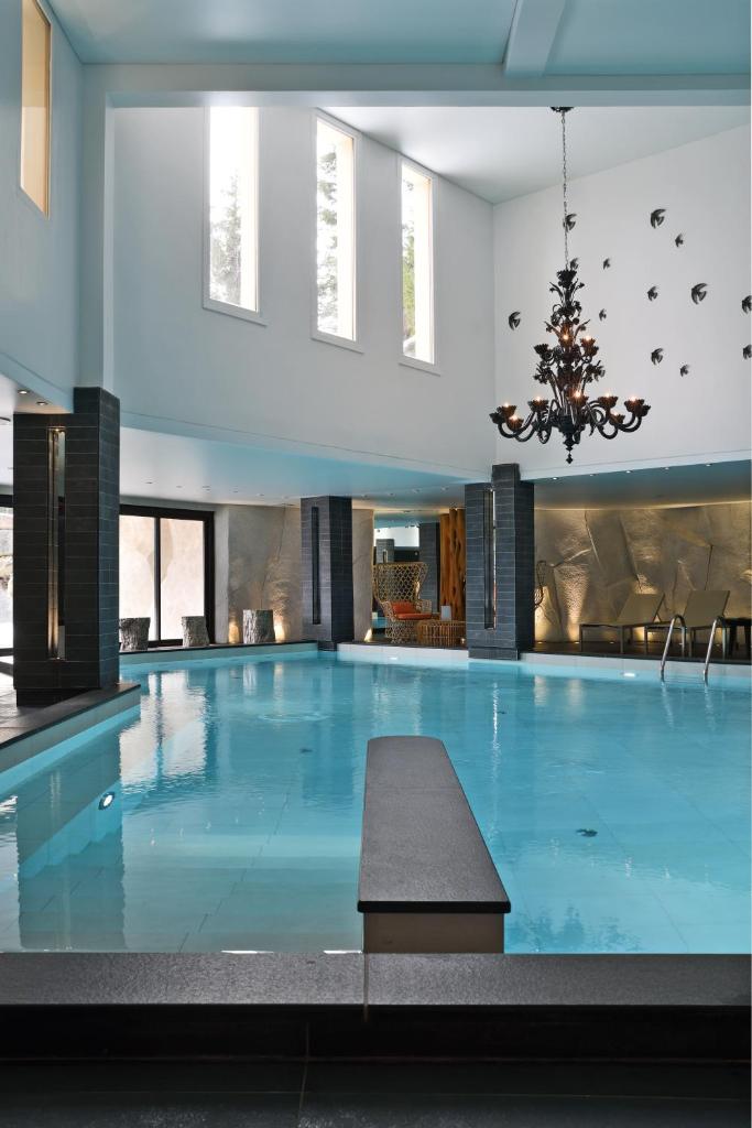 une grande piscine avec un lustre dans l'établissement Le Strato, à Courchevel