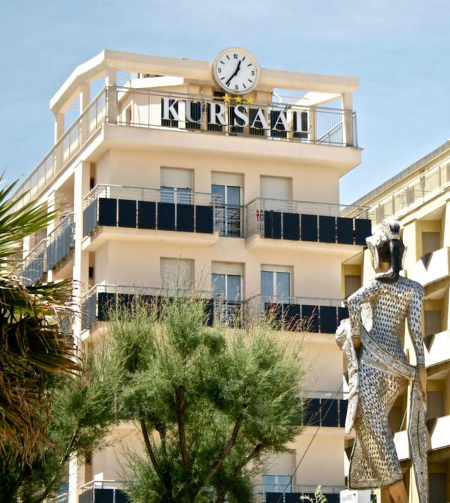 un bâtiment avec une horloge au sommet dans l'établissement Hotel Kursaal, à Rimini