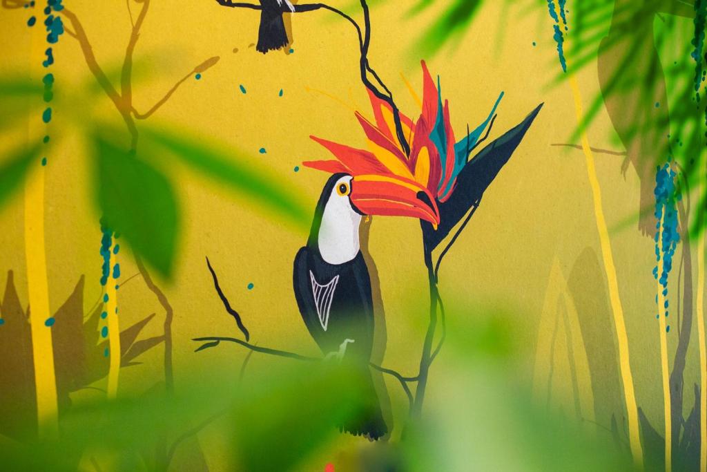 une peinture d'un oiseau sur un mur jaune dans l'établissement Costa Rica Bibione Aparthotel, à Bibione