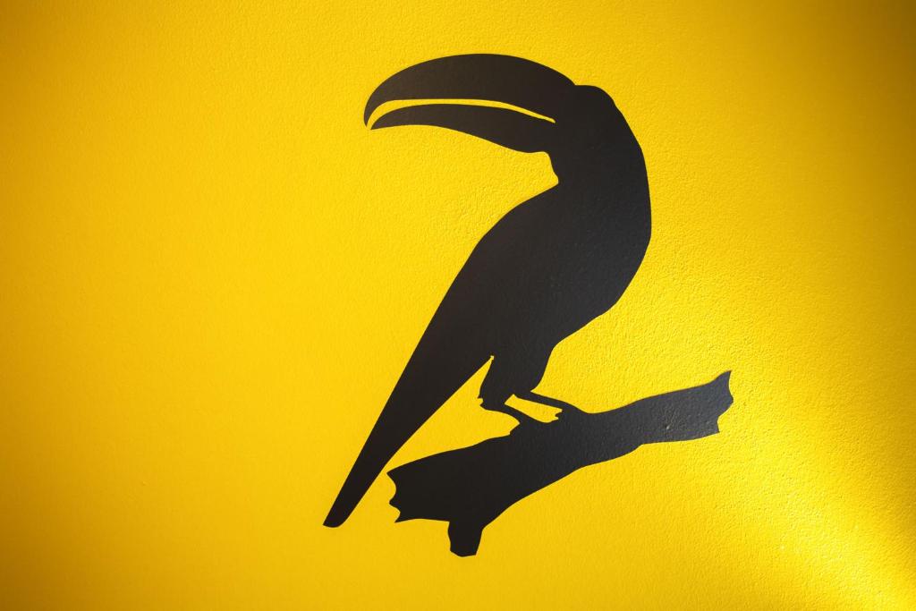 un signe avec un oiseau noir sur fond jaune dans l'établissement Costa Rica Bibione Aparthotel, à Bibione