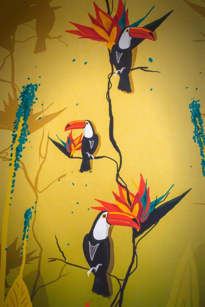 une peinture de deux oiseaux sur une branche fleurie dans l'établissement Costa Rica Bibione Aparthotel, à Bibione