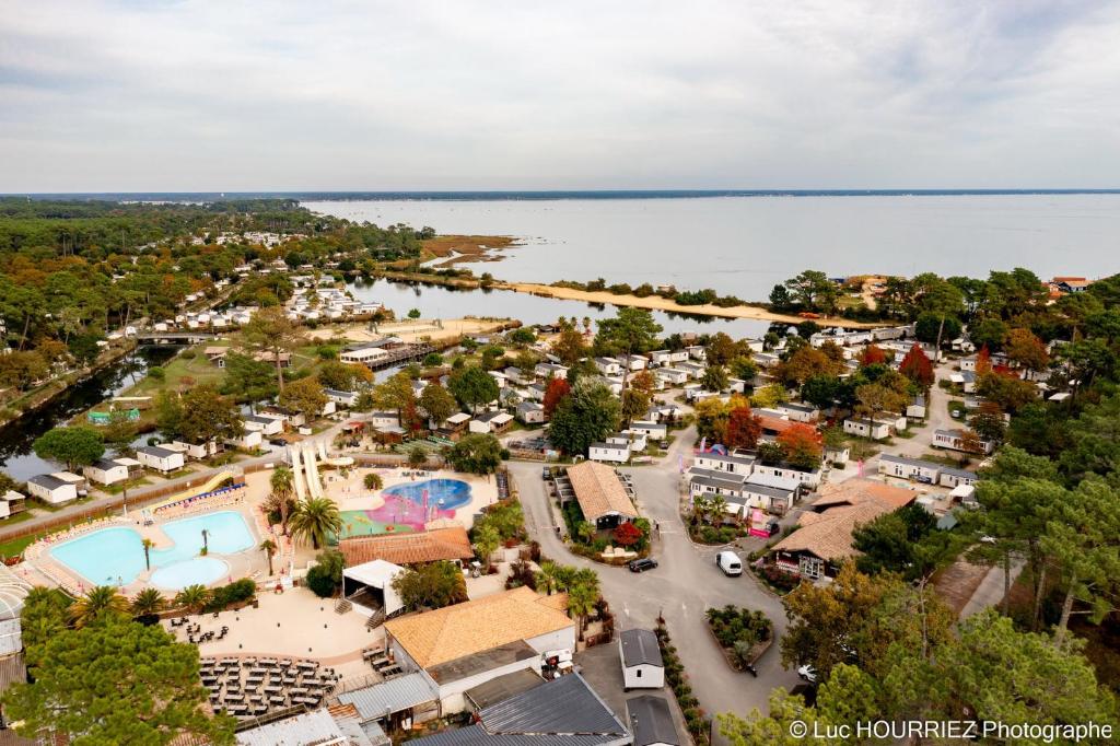 une vue aérienne d'un complexe hôtelier au bord de l'eau dans l'établissement lesmobilhomesduferret - camping Les Viviers - mobil-homes de particuliers, funpass activités non inclus, à Lège-Cap-Ferret