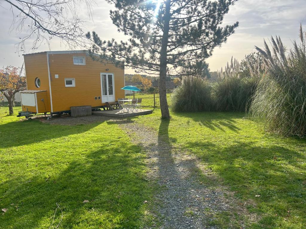 Une petite maison au milieu d'un champ dans l'établissement La tiny house Luna, à Villefranche-de-Longchat