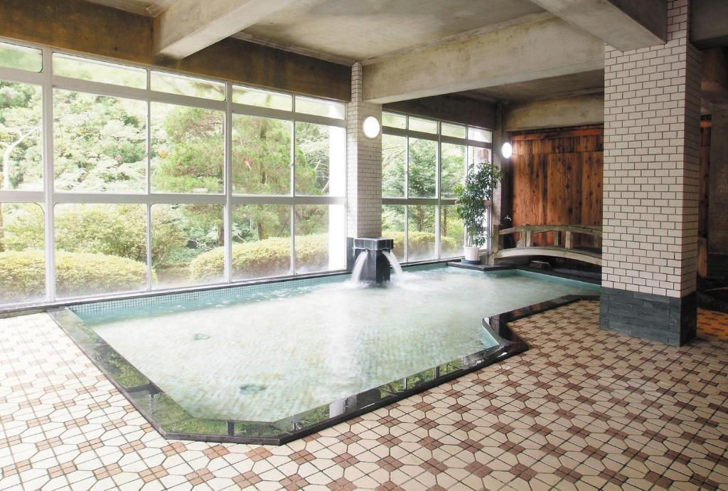 Cette chambre dispose d'une grande piscine et d'une grande fenêtre. dans l'établissement Irori Houraku, à Kamikawa