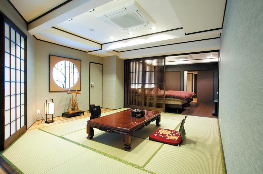 un salon avec une table et un lit dans l'établissement Irori Houraku, à Kamikawa 12 autres photos