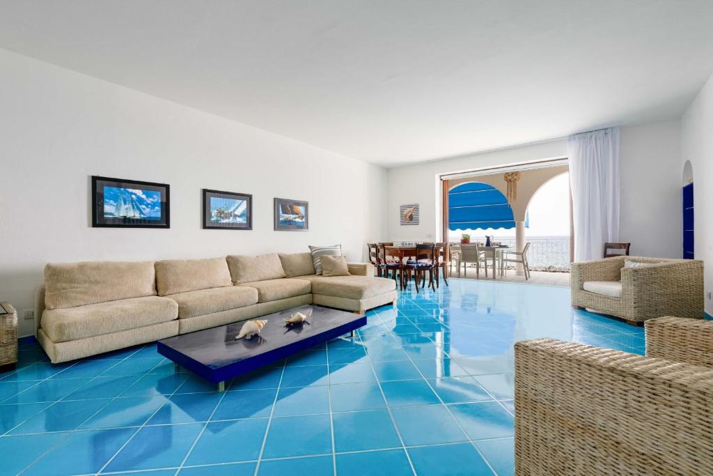 un salon avec un sol bleu et un canapé dans l'établissement AMORE RENTALS - Villa Marti, à Massa Lubrense