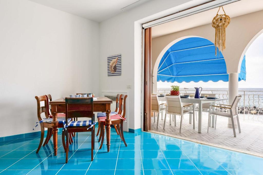 une salle à manger dotée de carrelage bleu et d'une table avec des chaises dans l'établissement AMORE RENTALS - Villa Marti, à Massa Lubrense