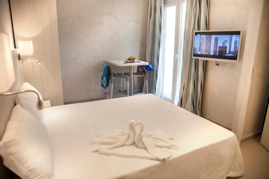 - une chambre avec un lit et une serviette dans l'établissement Hotel Britannia Rimini Marina centro, à Rimini