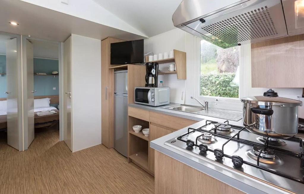 - une cuisine avec une cuisinière dans l'établissement Domaine Résidentiel de Plein Air Le Vorlen, à Fouesnant 20 autres photos