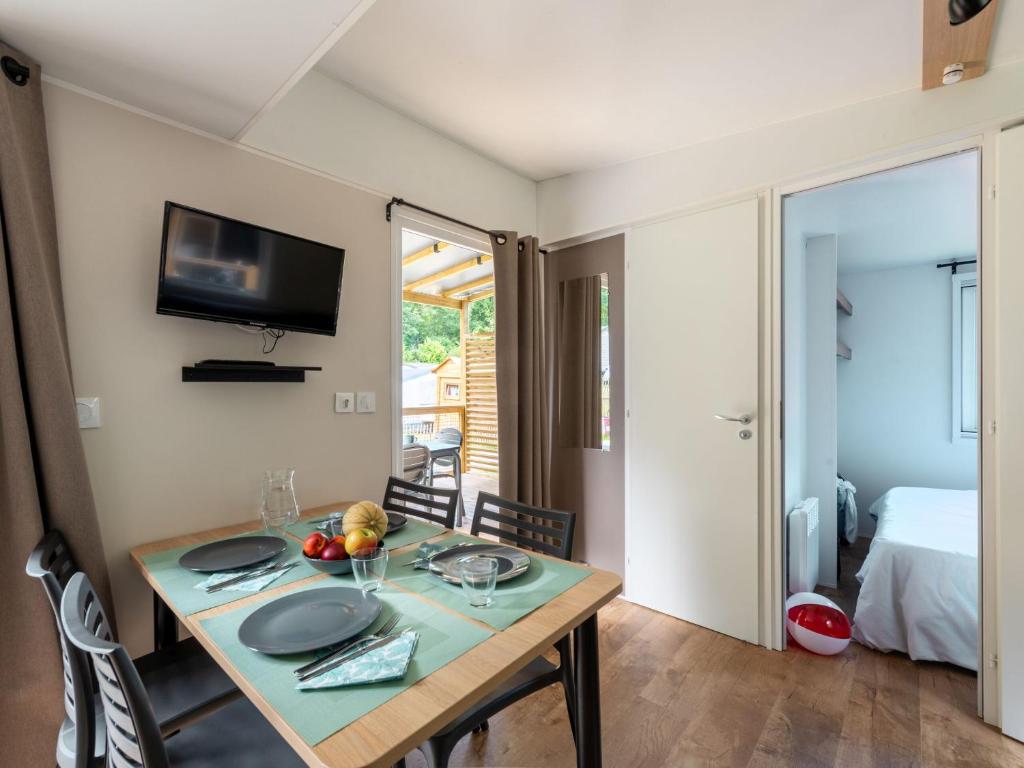 une salle à manger avec une table et une télévision dans l'établissement Domaine Résidentiel de Plein Air Le Port de la Chaine, à Pleubian