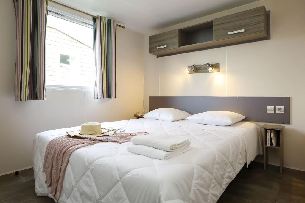 une chambre avec un grand lit blanc avec deux oreillers dans l'établissement Domaine Résidentiel de Plein Air Kerleyou, à Douarnenez 37 autres photos