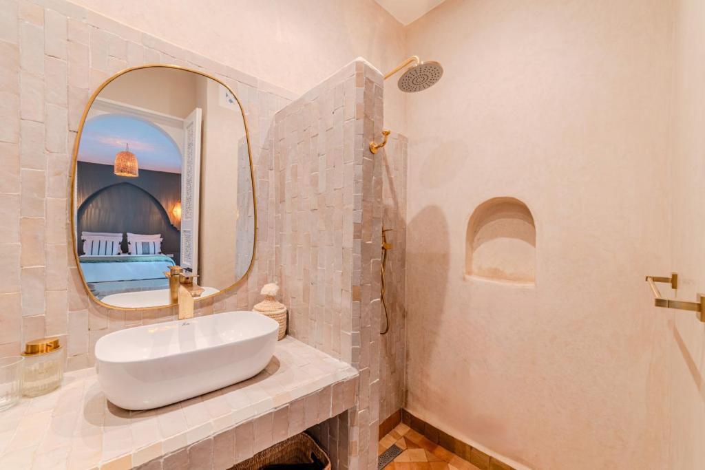 une salle de bain avec un lavabo et un miroir dans l'établissement Riad Dar Jamila Breakfast 10mn to Jamaa Al Fna, à Marrakech