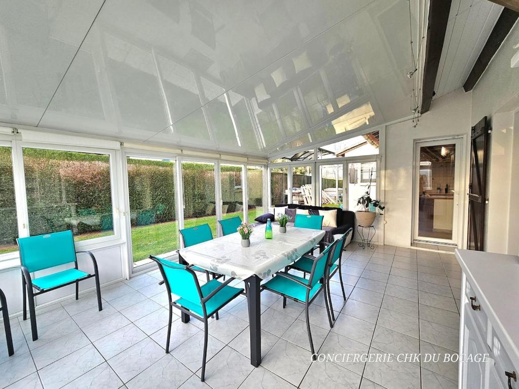 une salle à manger avec une table et des chaises bleues dans l'établissement La Casa - Gîte familal - 15min from Puy duFou, à Mauléon