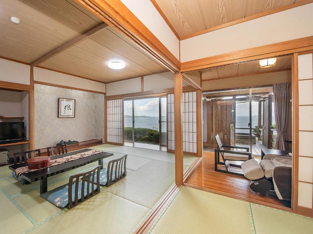 un salon avec vue sur l'océan dans l'établissement 絶景海風癒し庵 新八屋, à Toba