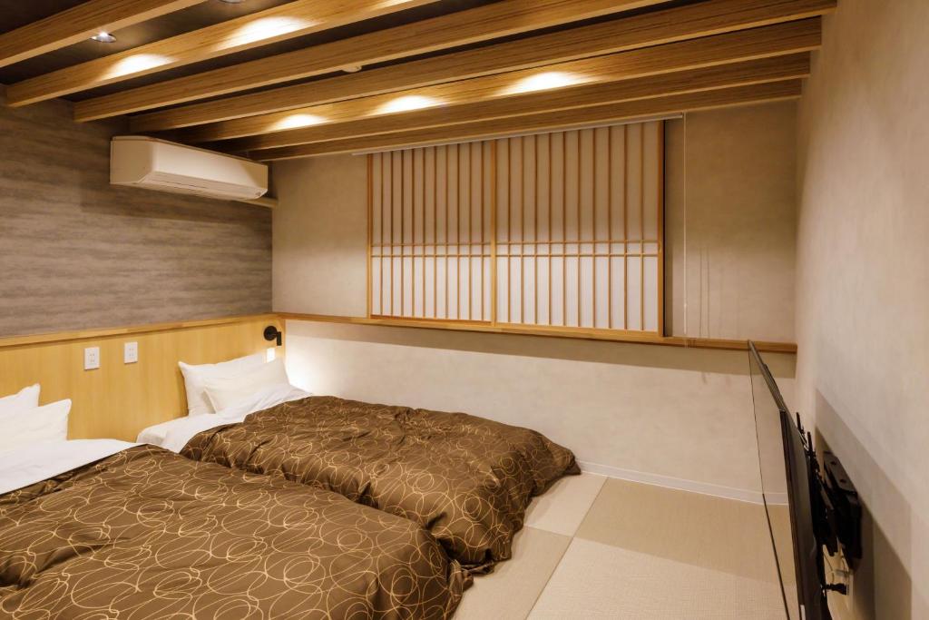 une petite pièce avec un lit et une fenêtre dans l'établissement 田沢湖水沢温泉郷セルリアンリゾートAoni, à Senboku