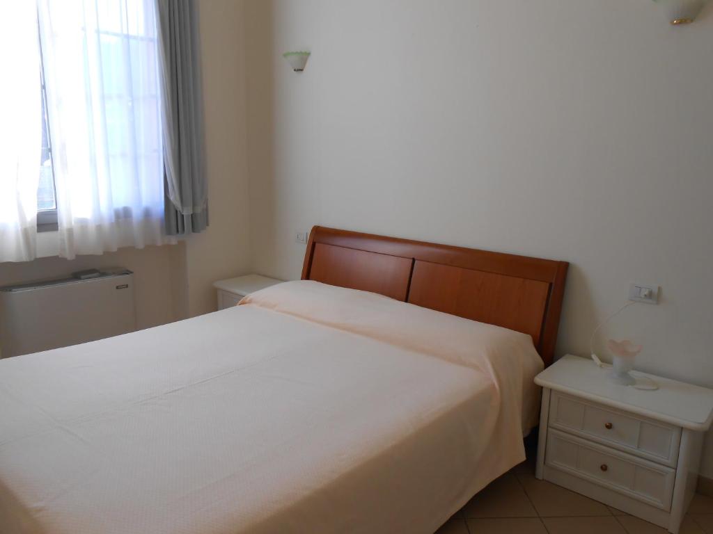 une chambre avec un lit blanc et une fenêtre dans l'établissement Residence Villa Marina, à Marina di Ravenna