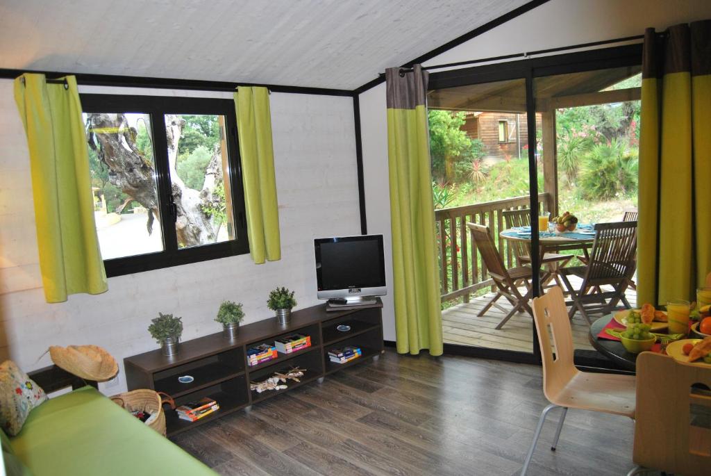 Il comprend un salon doté d'une télévision et d'un balcon. dans l'établissement Résidence Lagrange Vacances - Les Cottages Varois, à Solliès-Toucas