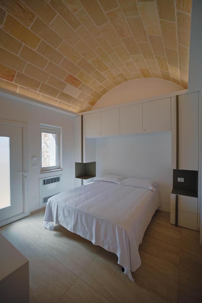 - une chambre avec un grand lit et un plafond à caissons dans l'établissement Resort San Giacomo con Piscina, à San Michele Salentino