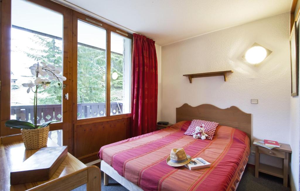 une chambre avec un lit avec deux chapeaux dessus dans l'établissement Résidence Odalys Les Hauts du Rogoney, à Val dʼIsère