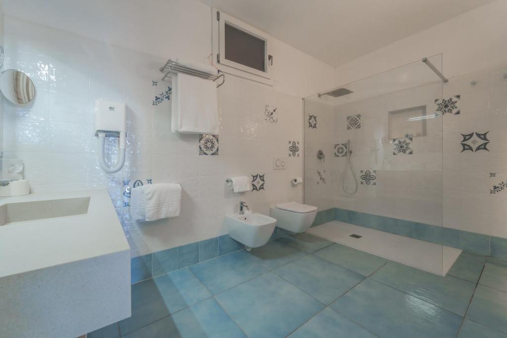 une salle de bain blanche avec toilettes et lavabo dans l'établissement Hotel Dino, à Capoliveri 122 autres photos