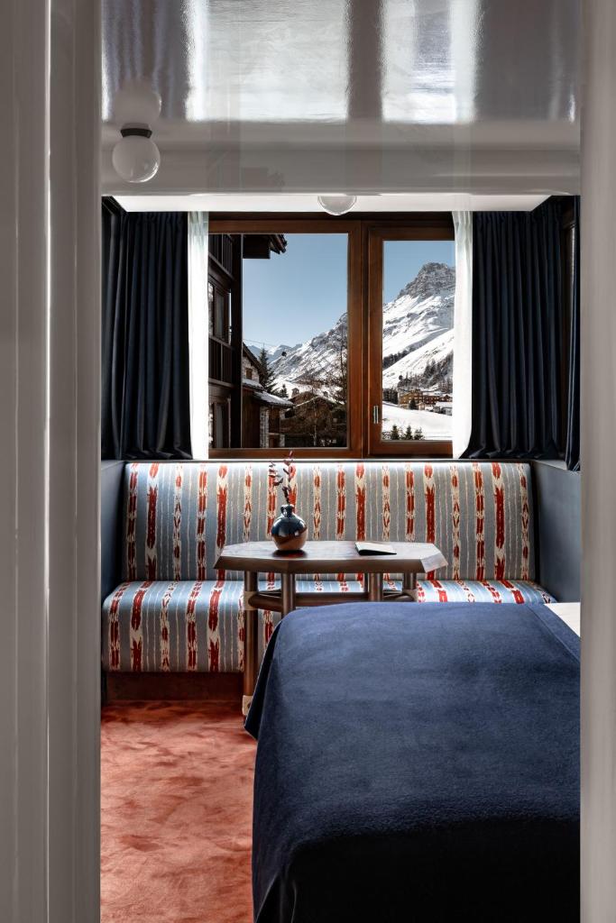 une chambre avec un canapé, une table et une fenêtre dans l'établissement Experimental Chalet Val d'Isère, à Val dʼIsère