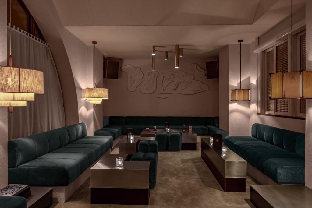 une salle d'attente avec des canapés et des tables verts dans l'établissement Experimental Chalet Val d'Isère, à Val dʼIsère