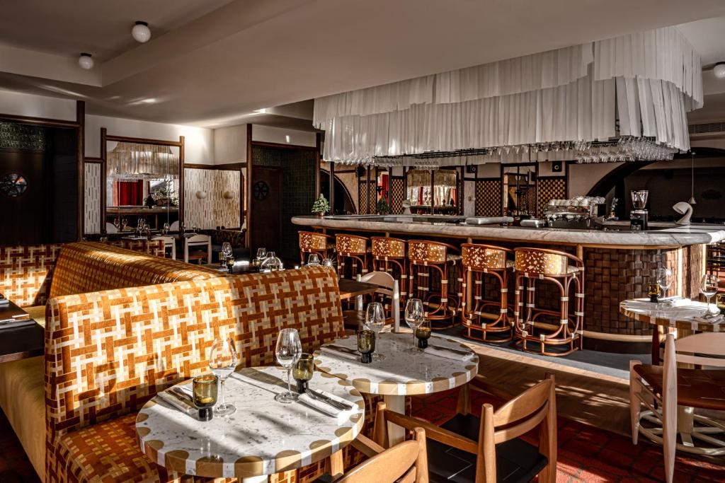 un restaurant avec des canapés et des tables ainsi qu'un bar dans l'établissement Experimental Chalet Val d'Isère, à Val dʼIsère