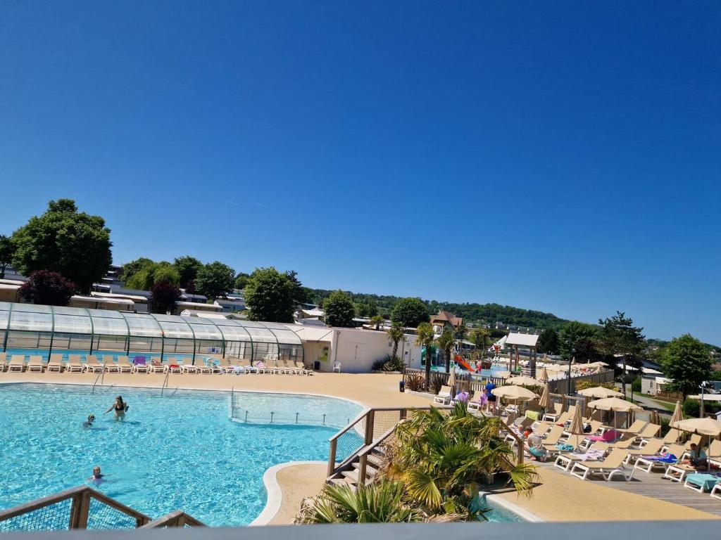 une grande piscine avec des gens dans un complexe hôtelier dans l'établissement Houlgate Mobilhome,3ch, 6pl, camp 5 étoiles, piscines, club enfants, à Houlgate